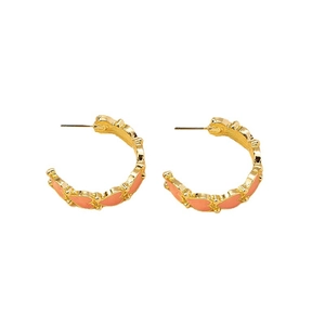 Boucles d'oreilles créoles dorées en C avec motifs de cœurs en émail rose sur fond blanc