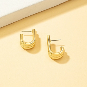 Detail of gold multi-layered linear alloy hoop earrings with a polished metallic finish
