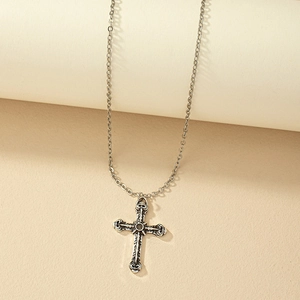 Vintage gothic cross necklace with textured engraving on elegant beige background