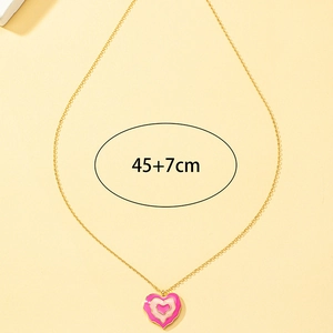 Détail du pendentif cœur en émail rose avec une chaîne dorée de 45cm plus 7cm