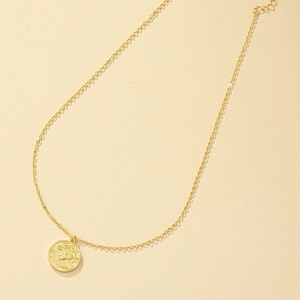 Elegante collana con ciondolo a moneta leone d'oro e catena a maglie su sfondo strutturato