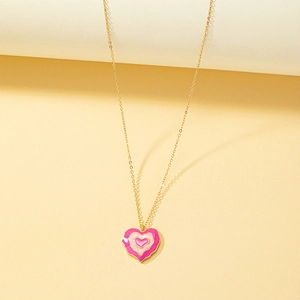 Vue détaillée d'un pendentif cœur en émail rose multicouche sur collier doré fin