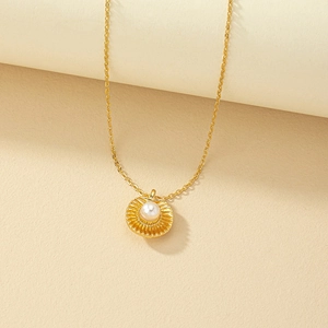 Collier doré avec pendentif soleil et perle centrale sur fond minimaliste texturé