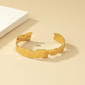 Bracciale rigido aperto dorato con texture martellata irregolare e diametro interno 5,8 cm