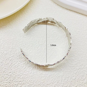 Dettaglio macro del bracciale aperto in argento martellato, diametro interno 5,8 cm