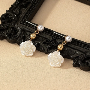 Elegant white camellia drop earrings with gold accents and pearls on vintage frame