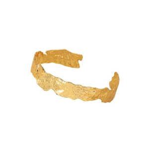 Bracciale rigido dorato minimalista con texture martellata irregolare e design in metallo