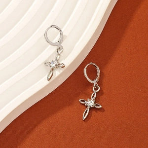 Detailed view of silver hoop earrings featuring a cross pendant and white zircon inlay