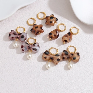 Leopard print bow earrings with pearls and acetate resin charms on white background