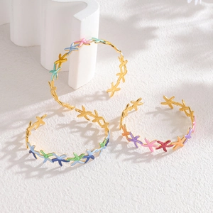 Dettaglio di tre bracciali a stella marina placcati oro 18k con smalto colorato