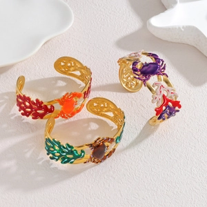 Detailed close-up of ocean-themed enamel bangles featuring crab and coral reef designs