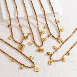 Detail of bohemian gold layered sweater necklace with charms and braided leather straps
