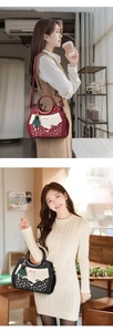 Nahaufnahme weinroter und schwarzer Handtaschen mit floralen Ausschnitten und Metallgriffen