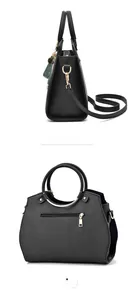 Details einer schwarzen Kunstledertasche mit runden Metallringen und Reißverschlusstasche