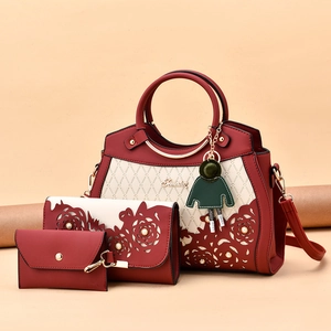Three-piece women's handbag set in deep red and cream with floral cutout and pearls