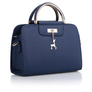 Dark blue embossed tote bag with gold deer pendant and round handles on white background