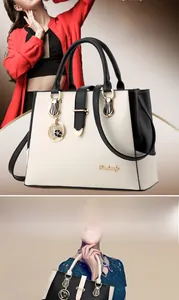 Close-up of color-block trapezoid handbag with gold hardware and heart floral pendant