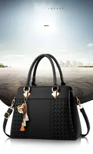 Détail de sac à main en cuir noir avec texture tressée et attaches dorées pour poignées