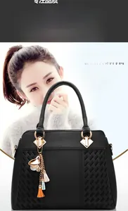 Détail du sac à main noir avec texture grainée et pendentif à pampilles multicolores