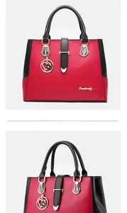 Detail of red and black PU leather handbag with gold logo and floral heart charm