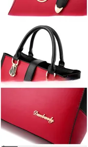 Detail view of reinforced handles and metal Danbaoly logo on red-black contrast PU bag