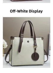 Detail view of cream white tote bag with geometric stitching and dark brown handles