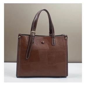 Close-up of retro color-block leather patchwork and gold buckle on a large tote bag