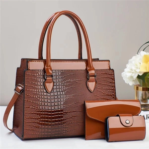 Detailed view of the three-piece lizard pattern tote bag set in dark caramel brown finish