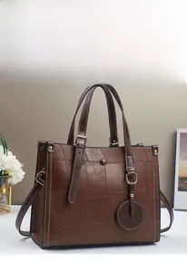 Detail view of retro brown patchwork tote bag with white stitching and gold hardware