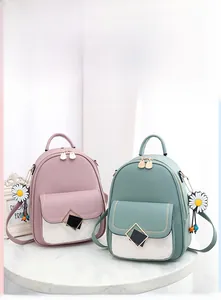 Detail of pink and green quilted backpacks with daisy pendants and square buckles