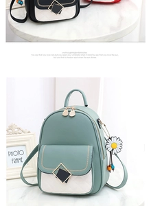 Detail of mint green mini backpack with white quilted pocket and daisy charm accessory