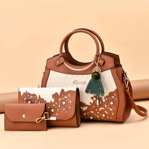 Three-piece set of brown and cream PU leather handbags with floral cutout detail