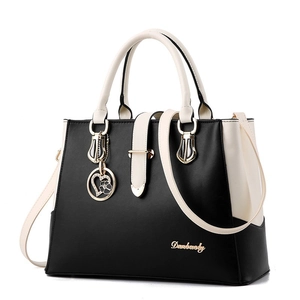 Two-tone PU leather handbag for women in black and cream with a golden heart charm