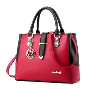 Fashionable red and black PU leather handbag with dual handles and gold heart pendant