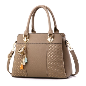 Sac à main classique en cuir grainé marron pour femme avec détails dorés et pompons