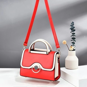 Stylish color-block crossbody bag with wave-edge flap and metal buckle on geometric stand