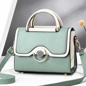 Modern color-block crossbody bag in mint green and beige with round gold metal handles