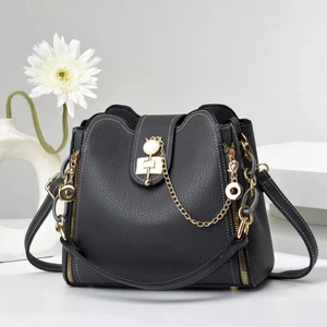 Fashionable black pebbled leather bucket bag with white contrast stitching and gold chain