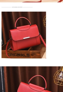 Detail of red faux leather handbag with silver metal bar on a wooden tray decor
