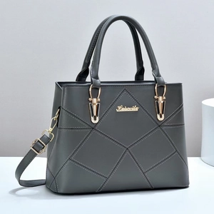 Dark grey geometric quilted handbag with gold metal logo and adjustable shoulder strap
