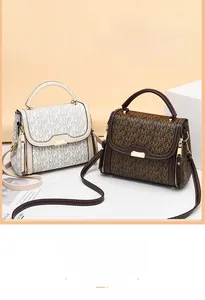 Detail view of printed crossbody bags with metallic clasp and adjustable straps