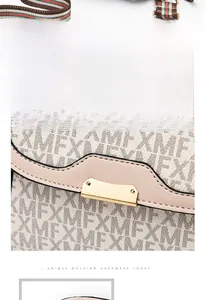 Detail of golden hardware lock and XMF monogram leather with striped webbing strap
