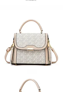 Detailed front view of beige monogram handbag with dual straps and polished hardware lock