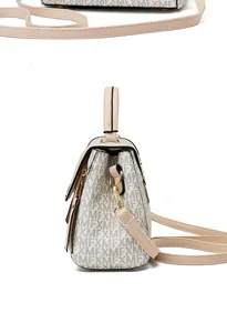 Detail view of cream handbag showing side and back angles with XMF monogram and gold hardware