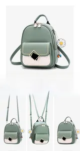 Detailed view of bicolor mini backpack showing multiple carrying styles and daisy charm