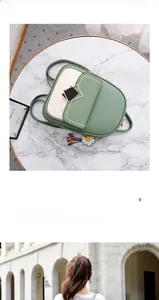 Detail view of a quilted green and cream leather backpack with daisy charm and metal buckle
