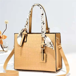 Elegante borsa beige con motivo a coccodrillo e sciarpa di seta decorativa sul manico