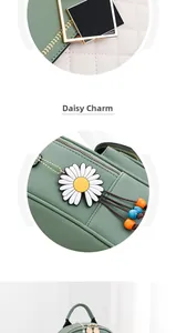 Detail of green quilted leather backpack with gold hardware and white daisy charm
