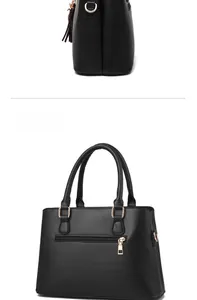 Detailed view of black leather handbag with rear zipper pocket and tassel charm