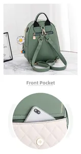 Detail of light green leather mini backpack with front pocket showing phone storage capacity